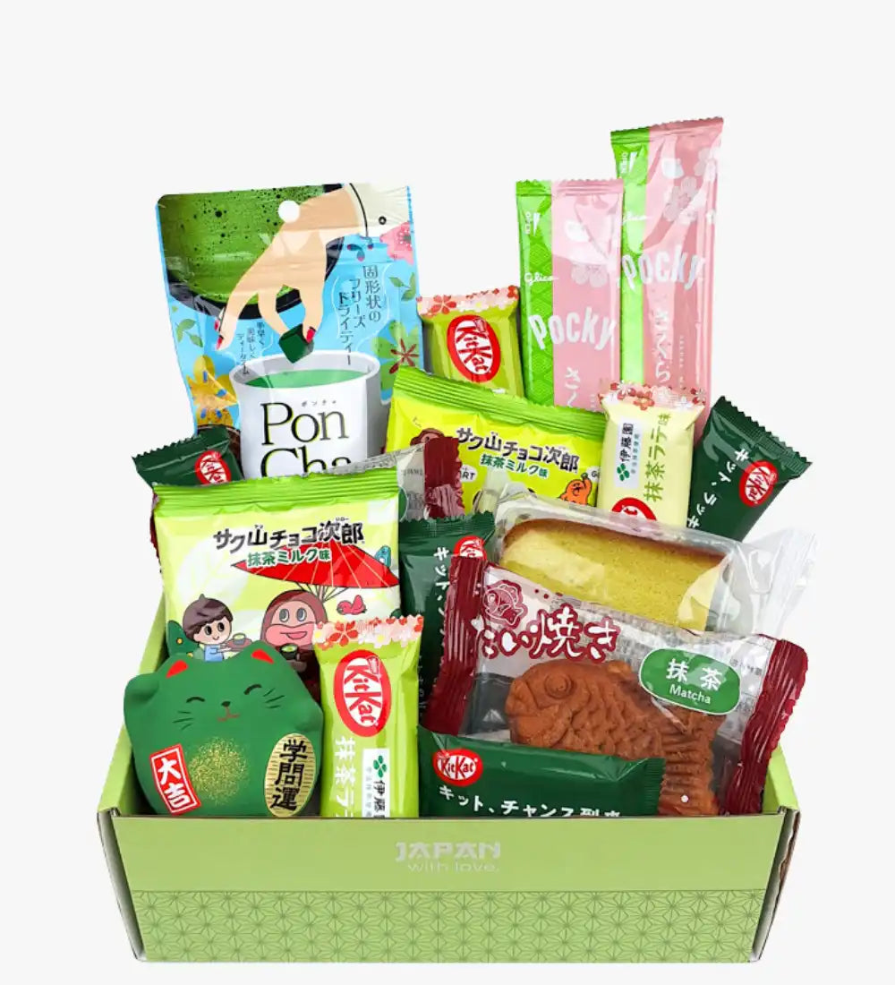 Una scatola regalo verde piena di vari spuntini e caramelle giapponesi.